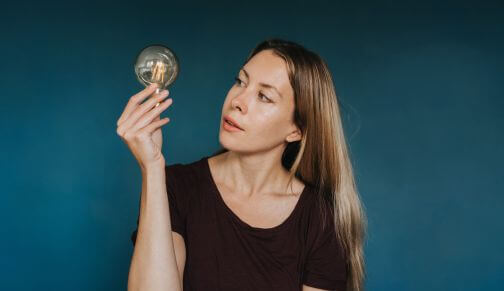 Femme observe ampoule